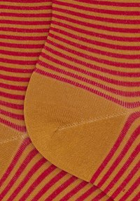 Calze a righe nei colori rosso e giallo, con una texture liscia e sezioni del tallone e delle punte in giallo uniforme.