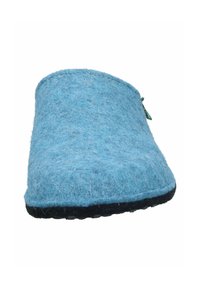 Blue felt slippers with a rounded toe, textured surface, and black rubber sole. Features a small green tag on the side.
