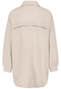 Overmaat beige overhemd van een gestructureerde stof, met een klassieke kraag en lange mouwen met elastische manchetten. De achterkant heeft een yoke-detail.