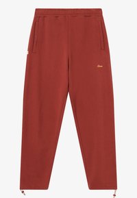 Punased dressipüksid, millel on nööriga tupe, kaks külgmist taskut ja kuldne logo tikand vasaku tasku lähedal. Pehme kangas sujuva tekstuuriga.