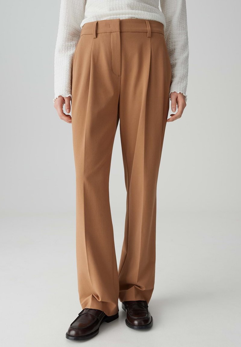 Bruine op maat gemaakte broek met een hoge taille, geplooide voorkant en wijduitlopende pijpen. Gemaakt van een gladde stof, met een nette afwerking en riemlussen.