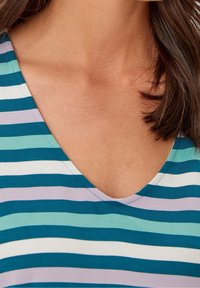 Haut à manches courtes et col en V présentant des rayures horizontales en vert-bleu, bleu clair, violet et blanc. Tissu en coton doux avec une texture lisse.