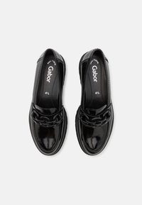 Zwarte lakleren schoenen met een lage hak, voorzien van een kettingaccent aan de voorkant en een ronde neus. Merkennaam "Gabor" zichtbaar aan de binnenkant.