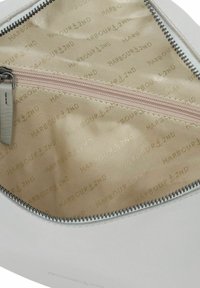 Borsa in pelle bianca con chiusura a zip, caratterizzata da un interno beige foderato con motivi ripetuti "HARBOUR 2ND". Texture liscia.