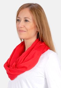 Red infinity scarf made of lightweight fabric, featuring a soft texture and smooth, unembellished design. Worn loosely around the neck.