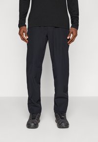 Black lightweight pants made of durable fabric, featuring a straight-leg design and side pockets, worn with matching black footwear.