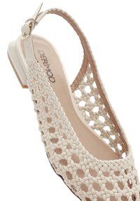 Beige woven slingback sandal featuring a braided design, low heel, and a smooth inner lining. Accented with a metallic buckle.