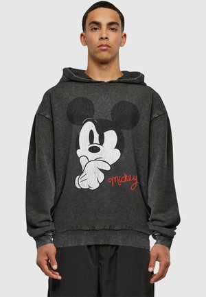 Black hoodie with a graphic of Mickey Mouse in white, featuring a graphic style and red "Mickey" text. Soft, casual fabric, oversized fit.