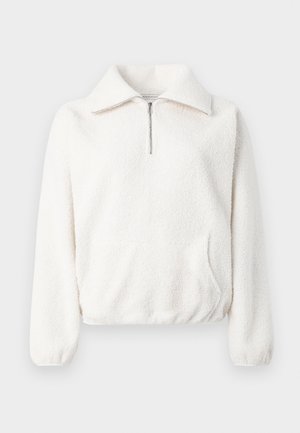 Valge pikkade varrukatega fliisist pullover, millel on veerand-suudme lukk, lai kaelus, elastsed mansetid ja elastne alläär.