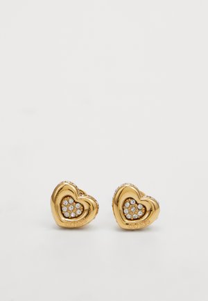 Orecchini a forma di cuore in oro con un grappolo di cristalli trasparenti al centro, con una finitura liscia e lucida e il nome del marchio inciso.