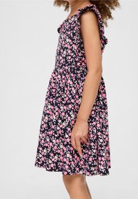 Granatowa sukienka w różowo-białe kwiatowe wzory, z falbaniastymi detalami na ramionach, długości do kolan, wykonana z miękkiego materiału.