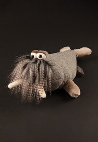 Grey plush walrus toy with fuzzy whiskers, large eyes, and tusks. Textured body and soft paws in contrasting beige material.
