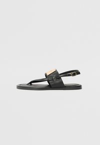 Sandale negre din piele cu talpă plată, având un design cu baretă frontală, curea la gleznă ajustabilă și un accent din metal auriu mat.
