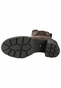Botte en cuir marron avec une semelle en caoutchouc texturée, présentant un motif de bande de roulement et un petit logo près du talon. La tige a une finition lisse.