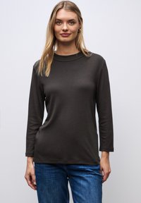 Bruine langemouwen t-shirt met een ronde hals, een gladde textuur en een slim fit silhouette, gecombineerd met blauwe spijkerbroek.