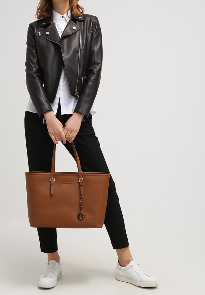 Brązowa skórzana torba na ramię z dwoma uchwytami, gładką teksturą i metalowymi elementami. Posiada płytkę z logo oraz zamek błyskawiczny.