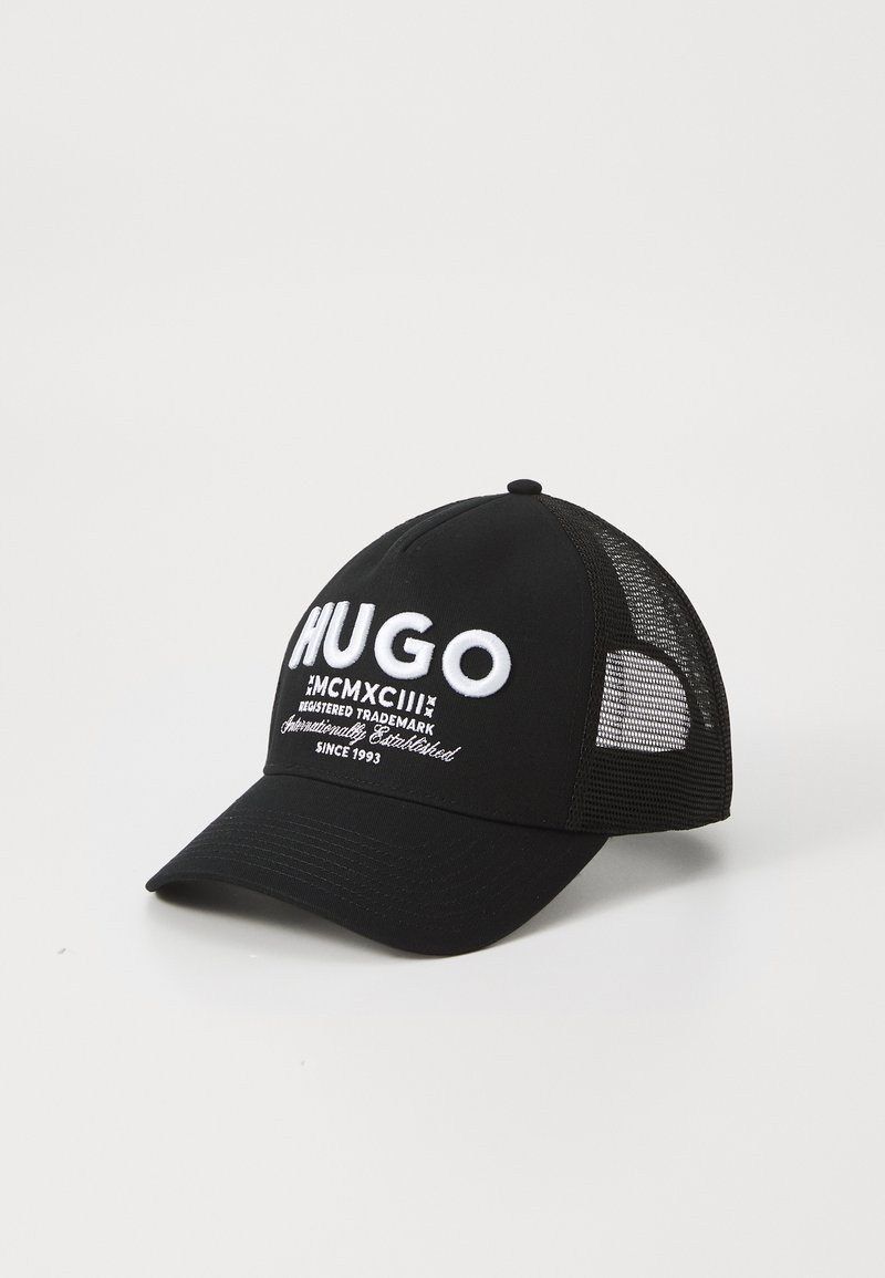 Casquette de baseball noire avec le mot "HUGO" brodé en lettres blanches, dotée d'un devant solide et d'un dos en mesh pour une meilleure ventilation. Visière incurvée.