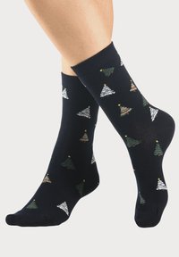 Dunkelblaue Knöchelsocken mit bunten Weihnachtsbaum-Mustern in Grün, Weiß und Rot, die mit gelben Sternelementen durchzogen sind.