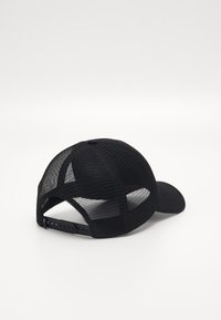 Svart keps med en böjd skärm, tillverkad av tyg och nät. Har en snapback-stängning och texturerade nätpaneler för ventilation.