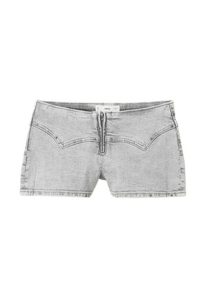 Mini-jupe en denim gris clair avec fermeture éclair frontale, coutures décoratives et détails de rivets le long de l'ourlet.