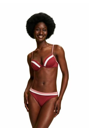 Rød bikini sæt med en trekantet bh med hvide detaljer og justerbare stropper, parret med matchende lavtaljede bund med en stribet talje. 