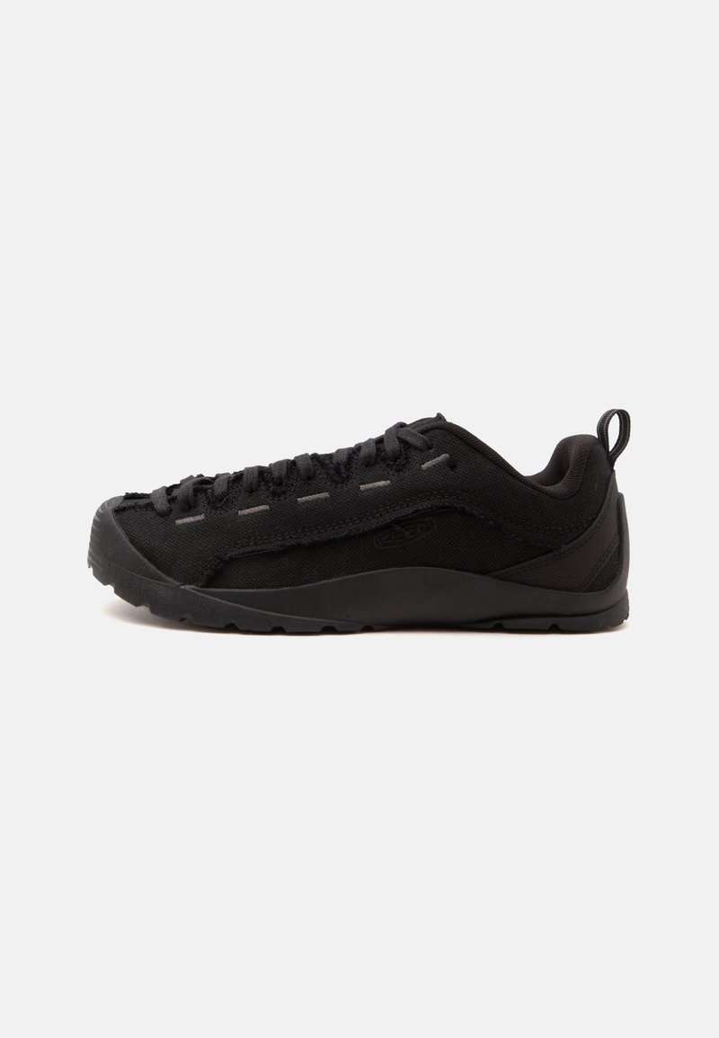 Chaussure de randonnée basse noire avec semelle texturée, fermeture à lacets et languette à l’arrière, vue de profil sur fond blanc.