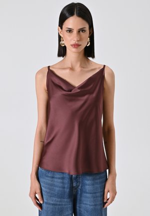 Ärmelloses Top mit Stehkragen aus dunkelburgunderfarbenem Satin, das eine glatte Textur und eine lässige Passform bietet. Kombiniert mit blauen Jeans.