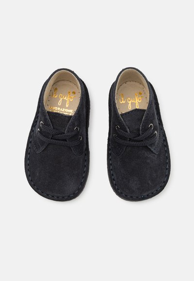 Pantofi din suede navy cu sireturi, având o margine cusută și o textură netedă. Brandul auriu 'il gufo' pe insole.