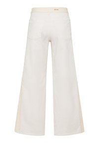 Weiße Hose mit weitem Bein, von hinten gezeigt, mit zwei Taschen, Gürtelschlaufen und einem kleinen "Brax"-Logo am Bund.