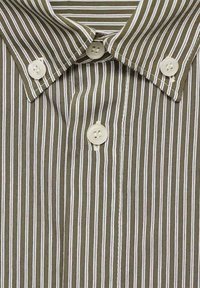 Camisa de botones a rayas con rayas verticales en verde oliva y blanco, con cuello puntiagudo y botones de plástico blanco.