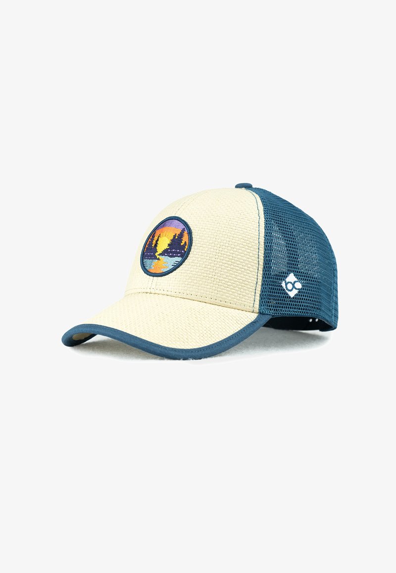 Trucker hat featuring a tan front panel with a textured surface, blue mesh sides, and a circular embroidered design with a sunset and trees.