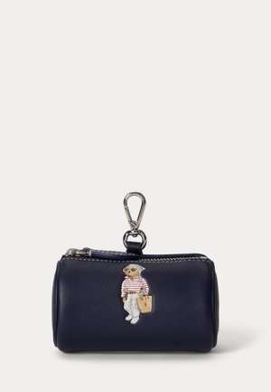 Pochette cylindrique bleu marine pour pièces avec tirette à fermeture éclair et clip argenté, ornée d'une illustration d'ours portant un pantalon blanc et un t-shirt rayé.