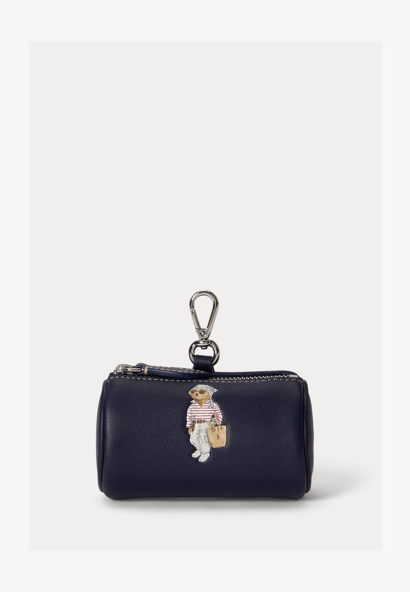 Navy blue cylindrical coin pouch with zipper pull and silver clip, featuring a bear illustration dressed in white pants and striped shirt.