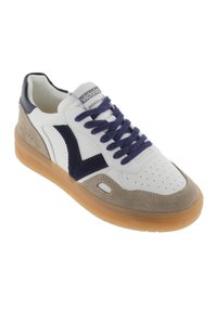 Sneakers bianchi in pelle con dettagli in suede blu navy, suola beige texturizzata e design classico con punta perforata e lacci.