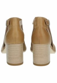 Tan leather high-heeled shoes with a textured, platform sole, open sides, and buckle detail at the ankle, featuring a striped heel design.