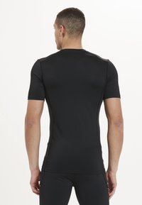Schwarzes sportliches T-Shirt mit kurzen Ärmeln, tailliertem Design, glatter Textur und nahtloser Verarbeitung. Verfügt über einen Rundhalsausschnitt und minimalistische Details.