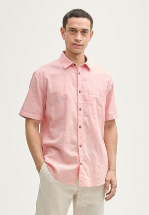 Chemise à manches courtes rose clair, boutonnée, en tissu léger, dotée d'une poche poitrine et de boutons marron, avec une coupe décontractée.