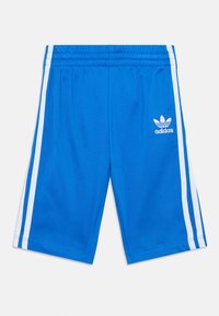 Blå Adidas-shorts med elastisk midja, vita sidostreck och Adidas Trefoil-logga på framsidan av högra benet.