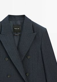 Blazer doppiopetto navy con motivo a righe sottili, ampi rever e bottoni neri. Interno foderato con etichetta "Massimo Dutti".