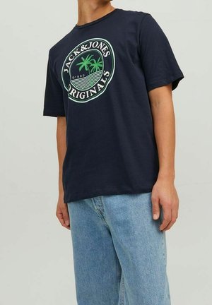 T-paita tummansinisestä puuvillasta, jossa on pyöreä vihreä grafiikka palmupuiden kanssa ja teksti "JACK & JONES ORIGINALS" valkoisella. Lyhyet hihat.