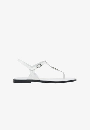 Witte platte sandalen van synthetisch materiaal, met een T-band ontwerp, verstelbare enkelband en een contrasterende zwarte zool.