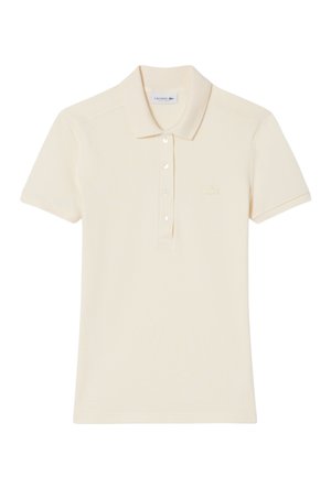 Polo de color beige suave, hecho de algodón. Cuenta con un cuello clásico, mangas cortas, tapeta con cinco botones y logo bordado en el pecho.
