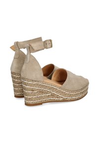 Beige ruskinds kilehæle sandaler med ankelstrop, rebdetaljer omkring bunden og åbent tådesign. Glat tekstur og let hævet hæl.