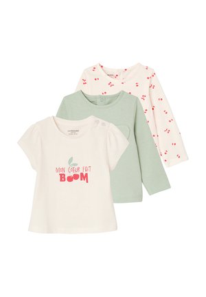 Three baby shirts: cream short-sleeve with pink "Mon Coeur Fait Boom" text and cherry graphic, green long-sleeve, and cream long-sleeve with red cherry print.