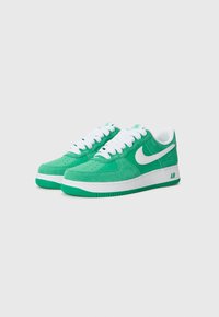 Green suede sneakers with white laces and a white Nike swoosh. Textured upper and rubber sole with a distinct air cushioning feature.
