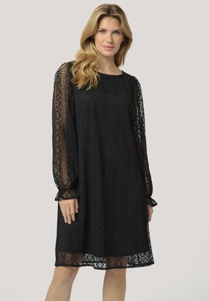 Black lace dress with long sleeves featuring intricate diamond patterns, elastic cuffs, and a loose, flowing silhouette, mid-thigh length.