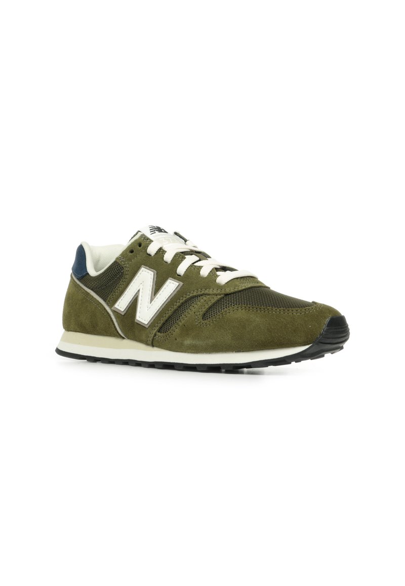 Zapatilla verde oliva con parte superior de ante y malla, acentos en blanco, cierre de cordones y suela de goma negra con textura en el dibujo.