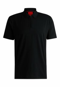 Polo nero in cotone, con patta a zip, maniche corte e colletto. L'interno del colletto presenta un'etichetta rossa a contrasto.