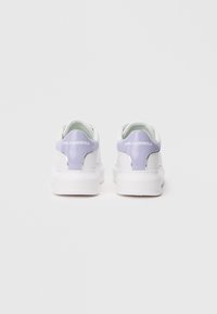 Bijele tenisice s sjajnim ljubičastim naglaskom na peti, s obloženim ovratnikom i bijelim potplatom. "Karl Lagerfeld" logo u bijeloj boji na peti.