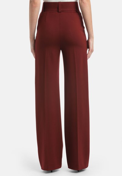 Pantaloni largi bordeaux cu talie înaltă și curea texturată. Țesătura pare netedă, având o croială ajustată și o finisare curată.
